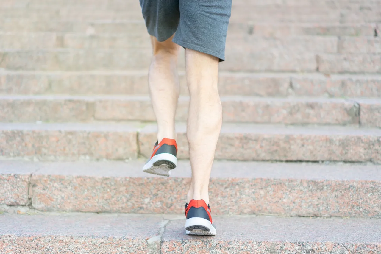 Đôi chân runner chạy lên bậc cầu thang đá, tiếp đất bằng nửa trước bàn chân